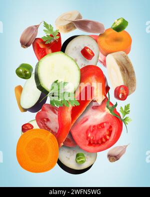 Different fresh vegetables and spices in air on light blue background Stock Photo