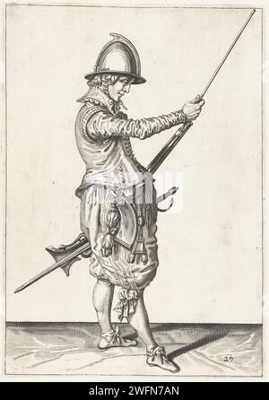 Soldier who pushes his chest of drawers in the holder under the course of his helm, Jacques de Gheyn (II) (workshop of), after Jacques de Gheyn (II), 1597 - 1607 print A soldier, to the right, to the right, who holds a rudder (a certain type of firearm) with his left hand at his left thigh and with his right hand slides the loading stick in the holder under the loop. This print is part of the series of 42 numbered prints of Roerschutters from the arms handling. Netherlands paper engraving manoeuvre  military training. firearms: rifle Stock Photo