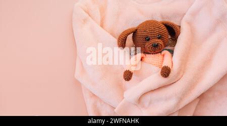 Soft pink sweater hugs a knitted toy on a pink background Stock Photo