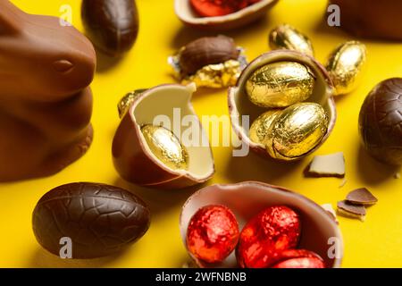 Chocolate Easter eggs and bunny on yellow background Stock Photo