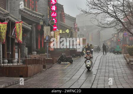 QINGZHOU, CHINA - JANUARY 31, 2024 - Tourists play at the Qingzhou Ancient City scenic spot with thick cotton-padded clothes in East China's Shandong Stock Photo