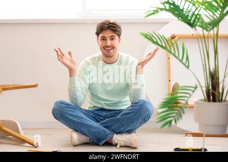 Young man assembling furniture in kitchen Stock Photo