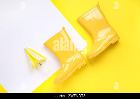 Mini stylish umbrella and gumboots on colorful background Stock Photo