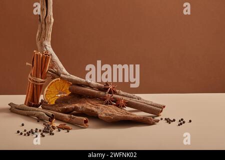 Some tree branches with a bunch of cinnamon sticks, dried orange slices and star anise placed on, many peppers scattered around. Organic herbal concep Stock Photo