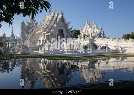 Chiang Rai, Thailand. 19th Jan, 2024. A general view of the White Temple with its reflection into the water pond. The 'Wat Rong Khun' most commonly known as the 'White Temple' was designed and constructed by famous Thai artist Chalermchai Kositpipat and opened to visitors in 1997. The Temple attracts a large number of visitors daily, both locals and tourists which makes it the number 1 attraction in Chiang Rai, Northern Thailand. Credit: SOPA Images Limited/Alamy Live News Stock Photo