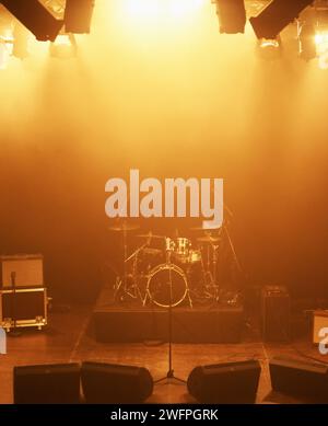 Concert, band and drums at stage for performance with instruments for live sound or gig. Music festival show, ready or background with lights or Stock Photo