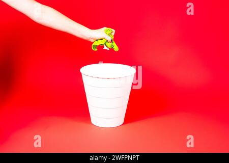Throw napkin in trash bin, house cleaning rag in hand in front of trash can, cleaning concept Stock Photo