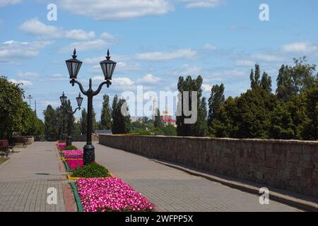 An alley with beds of flowers and lamp posts in Tambov with a church in the background Stock Photo
