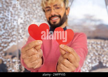 portrait smiling young woman holding hearts on Valentine's Day outdoors. Stock Photo