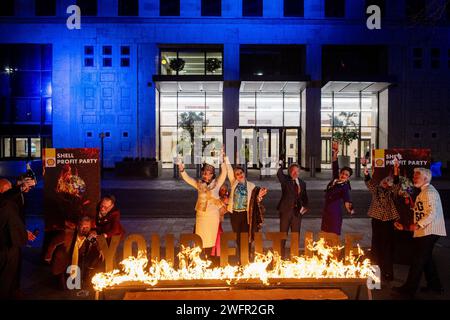 MANDTORY CREDIT, NO RESALE, NO ARCHIVE, FOR EDITORIAL USE ONLY, IMAGE AVAILABLE FOR PUBLICATION UNTIL 15/02/2024 Handout photo issued by Greenpeace of Greenpeace activists disguised as Shell executives drinking champagne and dancing around a burning sign reading 'Your Future' at a mock party outside the Shell headquarters in London, as the company announced its annual profits for 2023. Picture date: Thursday February 1, 2024. Stock Photo