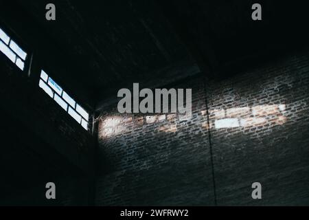 sunlight rays from large windows in dark warehouse Stock Photo