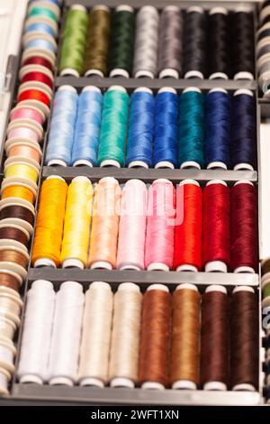 many colorful sewing threads on spools Stock Photo