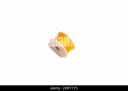 yellow sewing machine bobbin isolated on white background Stock Photo