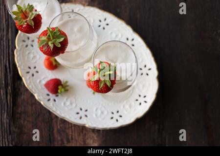 Glass of strawberry cocktail or mocktail, refreshing summer drink with champagne, strawberries, ice cream . Stock Photo
