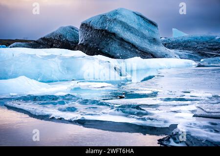 Small rocks on ice at sunset near water Stock Photo