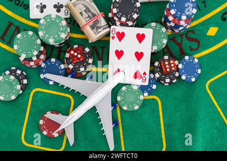 Dice, poker chips, playing cards and twisted 100 banknotes on the green table. Winning concept. Stock Photo