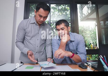 UX or UI designers designing on their smartphone application layout prototype project. Stock Photo
