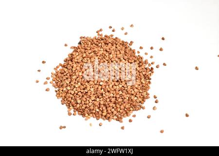 Brown buckwheat seeds lie in a heap on a white background. Stock Photo
