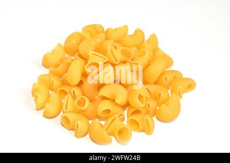 Pasta made from wheat flour lies in a heap on a white background. Stock Photo