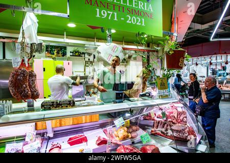 People buying meat at a butchers meat counter inside Florence Mercato Centrale, a busy, popular fresh food and produce market in Florence, Italy Stock Photo