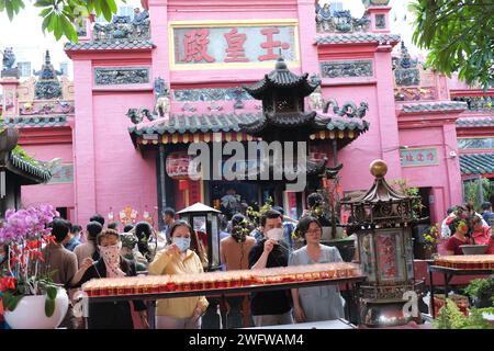 People light candles in front of the pink Jade Emperor Pagoda in Ho Chi Minh City, Vietnam Stock Photo