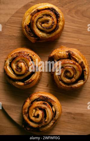 Rolls Cinnabon cinnamon and sugar, on a wood round dish isolated over wooden background. Stock Photo