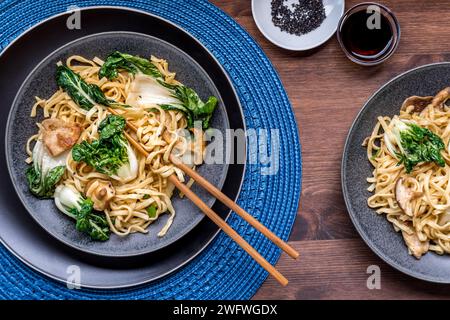 Servings of spicy pork and vegetable longevity noodles, ready for eating. Stock Photo