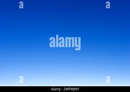 empty blue sky fading from white on the horizon to dark blue Stock Photo
