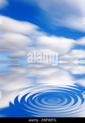 concentric waves on a water surface with blue sky and white clouds Stock Photo