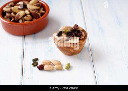 Various of berry, nuts and seeds in wooden bowl on a light wooden table. Stock Photo