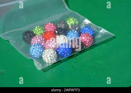 Beautiful, bright, multi-colored balls with Swarovski crystals chaotically arranged on a bright green background. Stock Photo