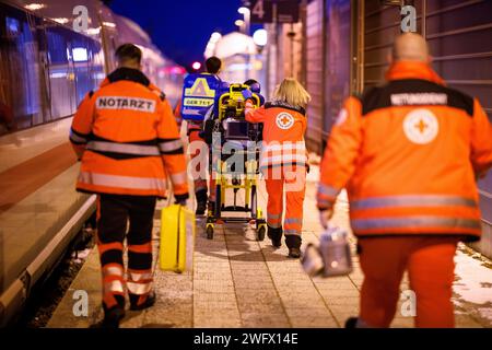Dachau, Germany. 20th Jan, 2024. Rescue workers from the Bavarian Red Cross push a patient, who was traveling as a passenger on a Deutsche Bahn ICE train, on a stretcher across a platform from Dachau station to the ambulance. Credit: Matthias Balk/dpa/Alamy Live News Stock Photo