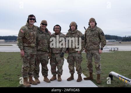 From left to right, 1st Lt. Colton Whitsell, 1st Lt. Dakota DeSantis, Capt. Hipolito Juarez- Gonzalez, Spc. Austin Johnson, and Sgt. Matthew Webb, assigned to 1st Battalion, 17 Infantry Regiment, 7th Infantry Division, pose for a picture after an aircraft familiarization flight during Air Assault University at Joint Base Lewis-McChord on Jan. 16, 2024.  The purpose of the class is to help mechanized infantry soldiers to understand the Air Assault Operation, how to get on and off helicopters, and basic PZ (pick up zone) Operation, LZ (landing zone) Operation, and Action on the objective. Stock Photo