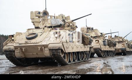 A formidable lineup of Bradley Fighting Vehicles, part of the 1st Squadron, 1st Cavalry Regiment, 2nd Armored Brigade Combat Team, 1st Armored Division, patiently awaits their turn to unleash firepower on a range at the Drawsko Combat Training Center, Poland on January 20, 2024. The soldiers of the 1st Squadron, 1st Cavalry Regiment have undertaken a myriad of training exercises, ranging from Abrams and Bradley Gunnery to an upcoming Platoon Life Fire Exercise. Stock Photo