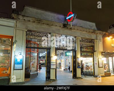 View of the colourful entrance to South Kensington tube station on the London Underground at night Stock Photo