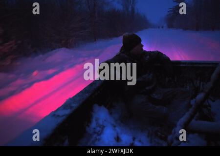 Staff. Sgt. Benjamin Rimatzki, a military police officer with the 46th Military Police Company, Michigan Army National Guard, sits in the back of a pickup truck after engaging a team with the 5th Special Forces Group while in the role of the opposing forces during Northern Strike 24-1 at Camp Grayling Maneuver Training Center, Michigan, Jan. 21, 2024. Northern Strike 24-1 is the winter warfare component of the annual National Guard Bureau-sponsored Northern Strike exercise series. Held at the Michigan National Guard’s National All-Domain Warfighting Center, which includes Camp Grayling Maneuve Stock Photo