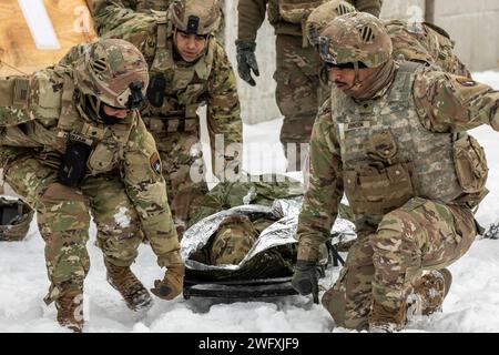 U.S. Army Soldiers from 2nd Battalion, 69th Armored Regiment and 4th Battalion, 27th Field Artillery Regiment, comprising elements of the 3rd Infantry Division-led Task Force Marne, start to carry a simulated casualty on a litter during a medical mass casualty exercise at Bemowo Piskie Training Area, Poland, Jan. 17, 2024. The medical mass casualty exercise involved Soldiers from four different countries including: the U.S. Army’s 3rd Infantry Division, the U.K. Eagle Troop, the 12th Croatian Contingent, and the Romanian Air Defense. The 3rd Infantry Division’s mission in Europe is to engage i Stock Photo