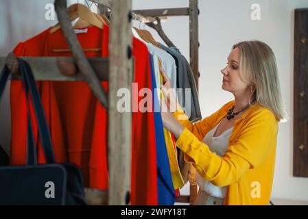 Woman chooses what to wear from the clothes in her wardrobe. Stock Photo