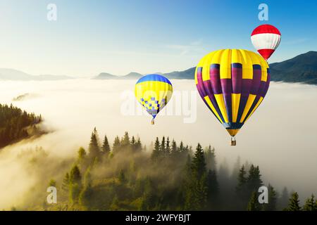 Hot air balloons flying over foggy mountains Stock Photo