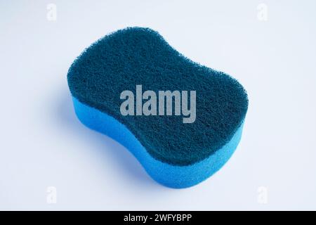 A blue dishwashing scrubber made with different materials on the top and bottom Stock Photo