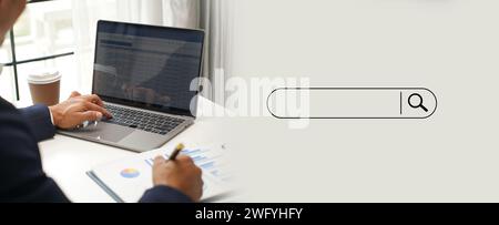 man Searching information is typing a keyboard Technology Search Engine Optimization on desk in office. Networking Stock Photo