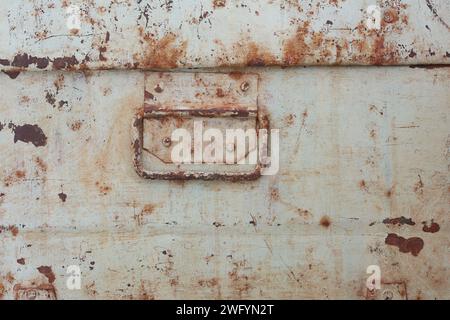 old and retro rusty metal surface background texture with handle of box, industrial concept of grunge backdrop for photography or wallpaper Stock Photo