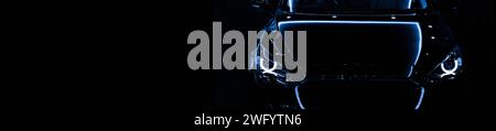Front view silhouette of black modern car with headlights on black background. copy space Stock Photo
