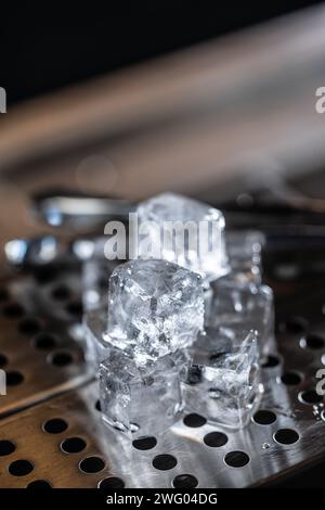 Crystal clear ice cubes on the stainless steel base of the bar counter. Stock Photo
