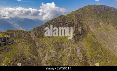 The Aonach Eagach ridge in Scotland is a narrow and precipitous crest.The majestic Scottish mountains soar into the sky, their craggy peaks piercing Stock Photo