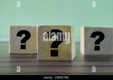 Concept of The wooden Cubes with the word Question marks on wooden background. Stock Photo