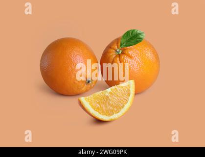 oranges with slice and leaf on light orange background Stock Photo