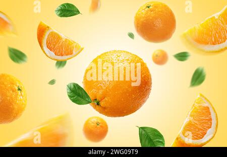 oranges with slices and leaves flying on light orange colour background Stock Photo