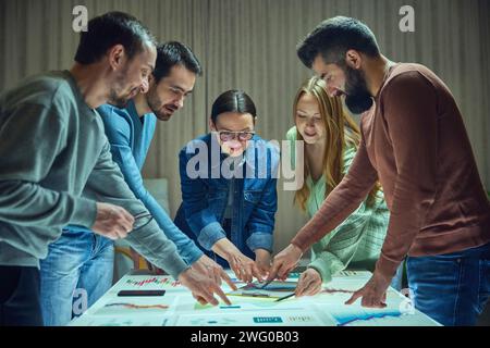 Project managers, business people working with digital table, checking analytics, chats statistics and data. Discussing further strategy for company Stock Photo