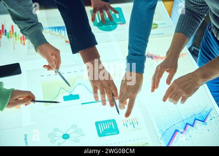 Project managers, business people working with digital table, checking analytics, chats statistics and data. Discussing further strategy for company Stock Photo